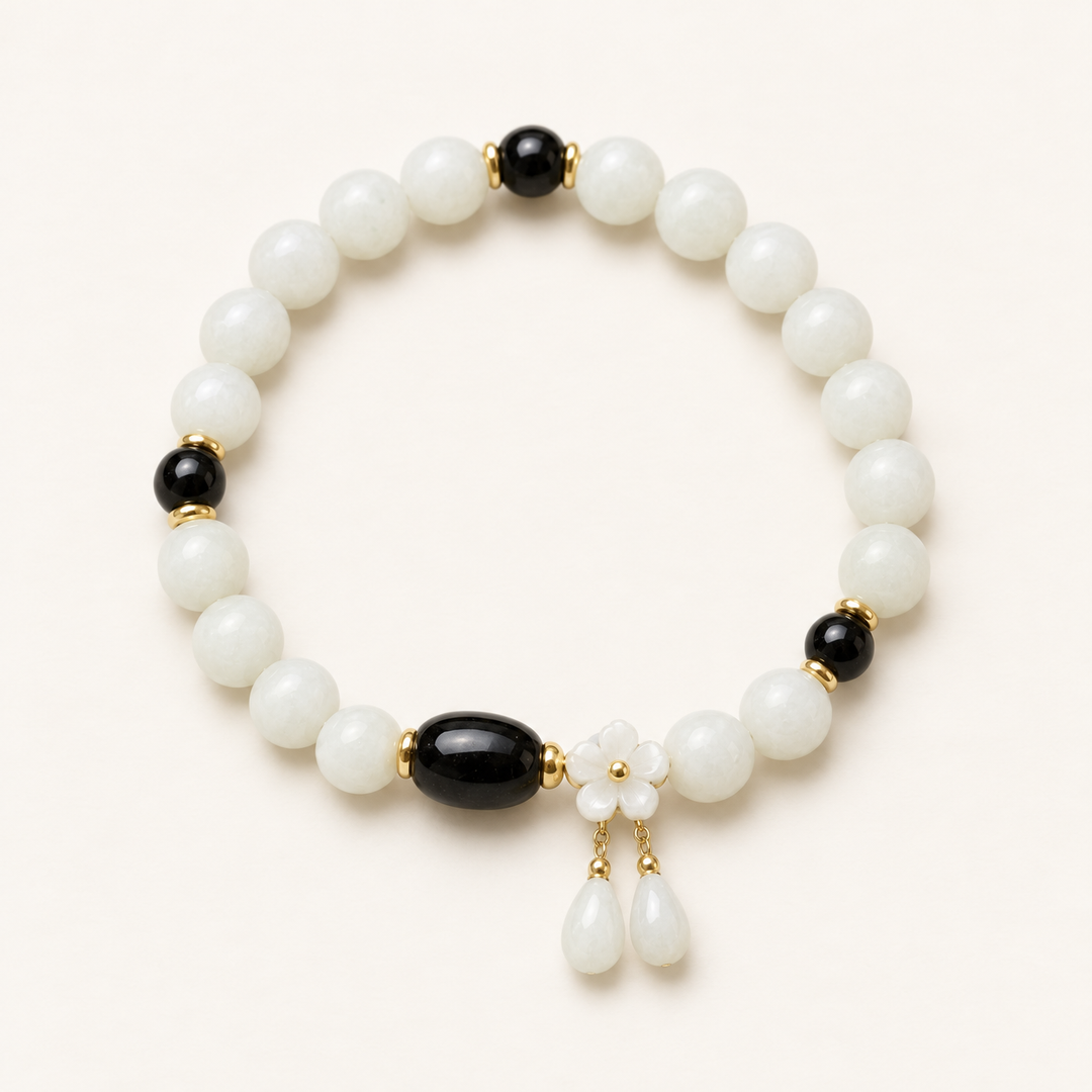 White Jade Guardian Bracelet with black tourmaline and flower charm, studio view